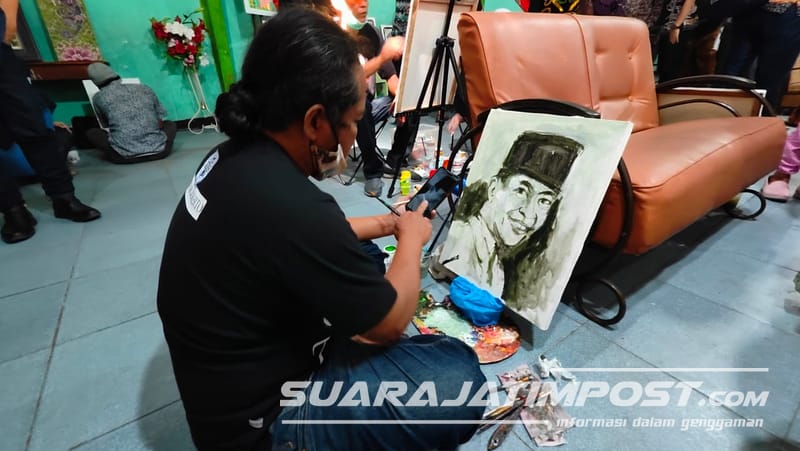 Seorang pelukis asal Mojokerto sedang melukis sosok Soekarno