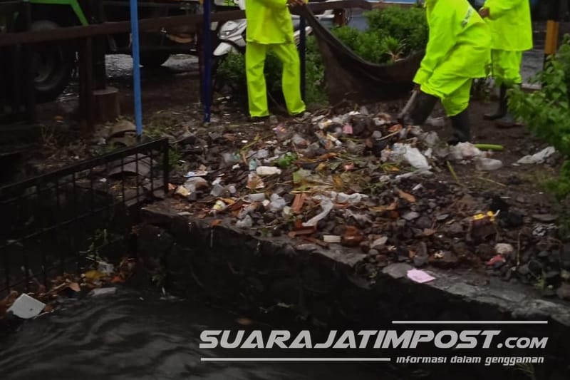 Petugas dari DLHKP ketika membersihkan sampah yang menyumbat saluran air. (Istimewa)